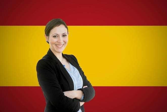 Young teacher standing before of the spanish flag