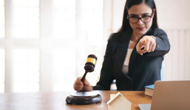 auction-and-real-estate-concept-woman-holding-judge-gavel-and-finger-picture-id1213684952