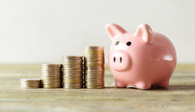piggy bank with coin on old wooden table