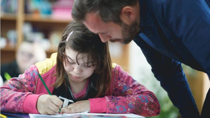 Educación especial, planificación centrada en la persona; un profesor ayuda a su alumna