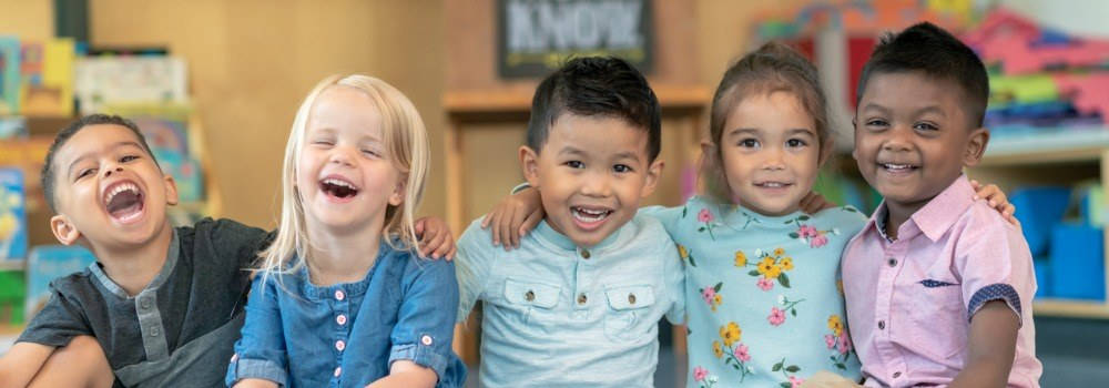 Educación infantil, expresión oral; un grupo de niños de infantil sonriendo y riendo