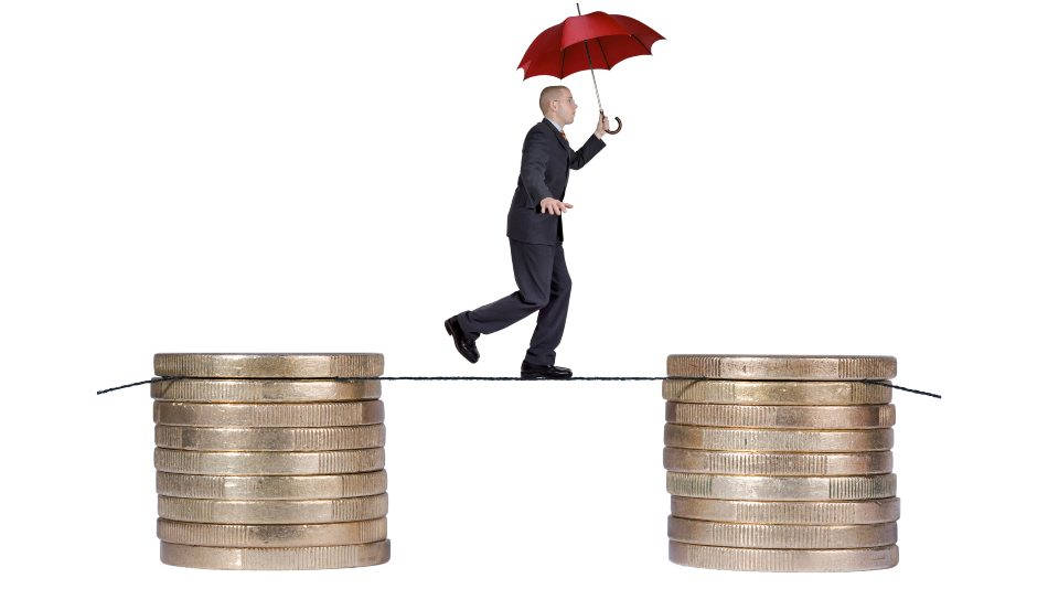 Carreras mejor pagadas. Equilibrista con paraguas rojo entre dos pilas de monedas