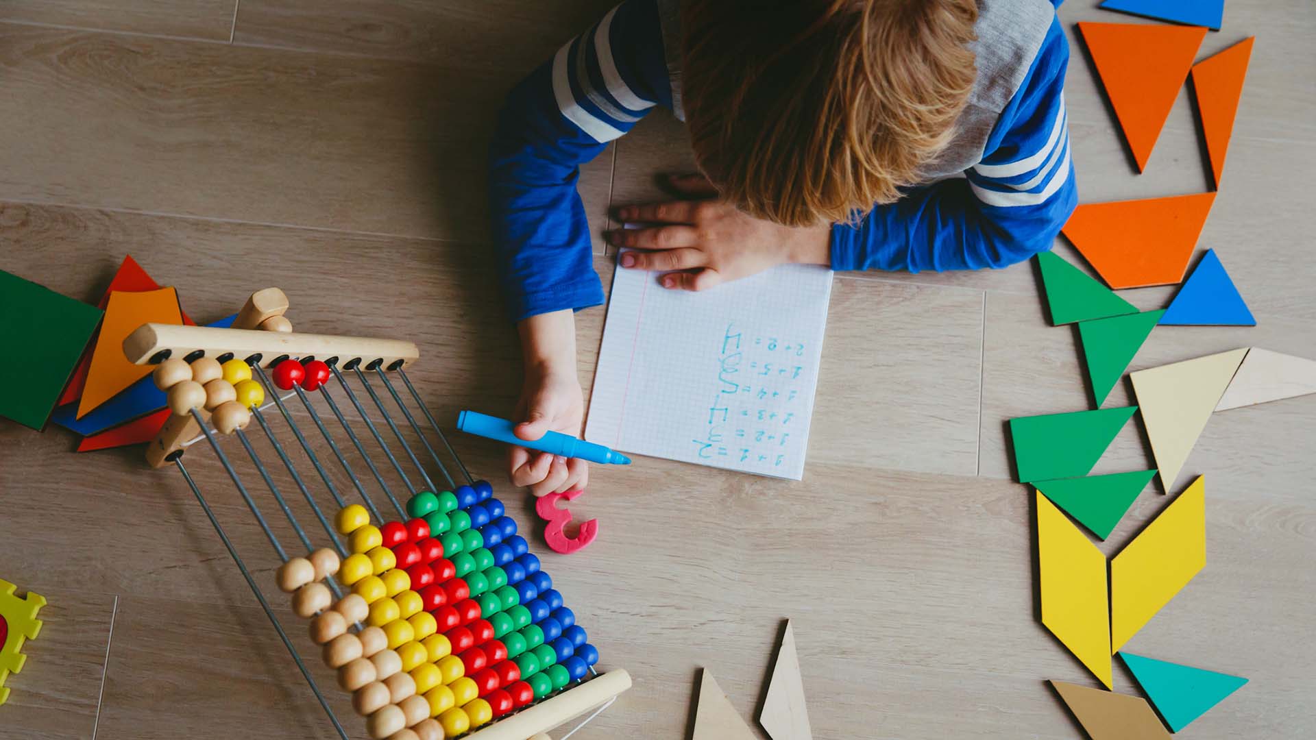Un niño aprende a escribir y a sumar