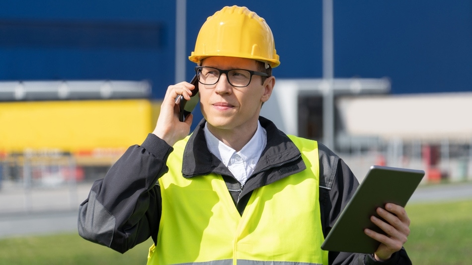 HSEQ manager hablando por el móvil con una tablet en la otra mano