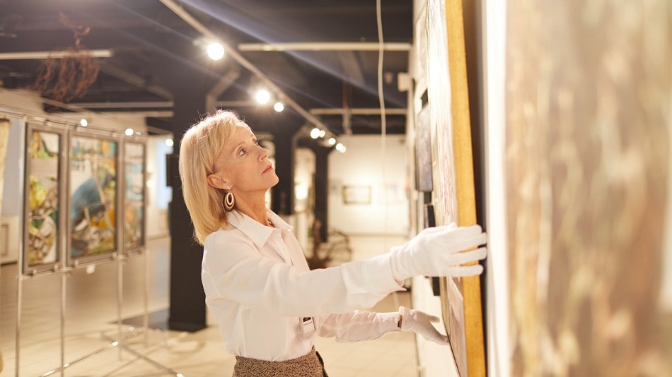 Galerista retocando la posición de un cuadro