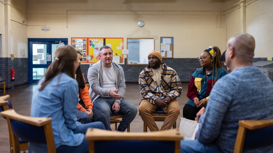 Trabajador social reunido con un grupo de inmigrantes en un centro social