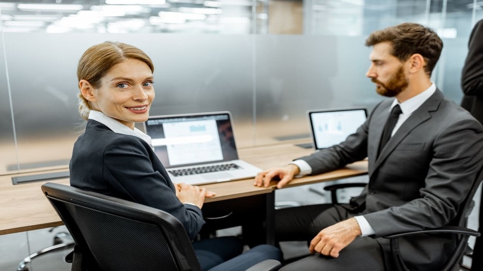 Dos auditores en una oficina con ordenadores sobre la mesa