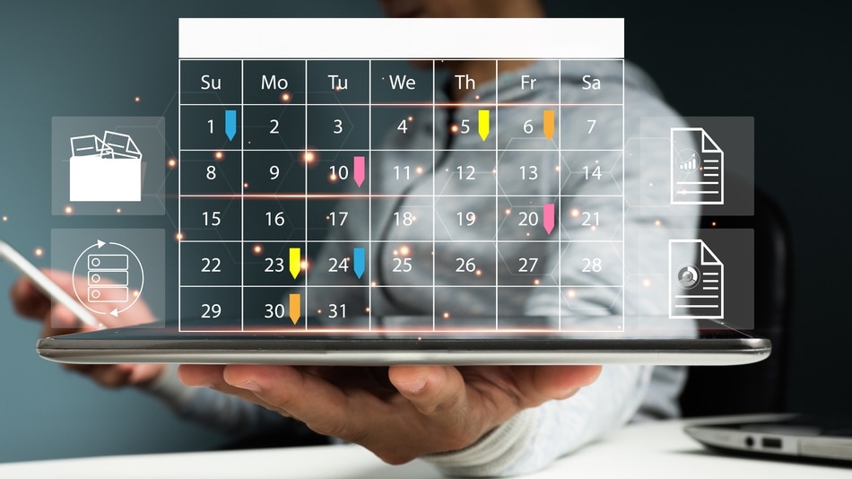 Hombre de negocios está usando su teléfono móvil y tomando notas en el escritorio del calendario