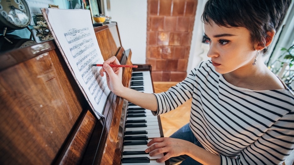 Joven pianista componiendo música en su habitación en casa