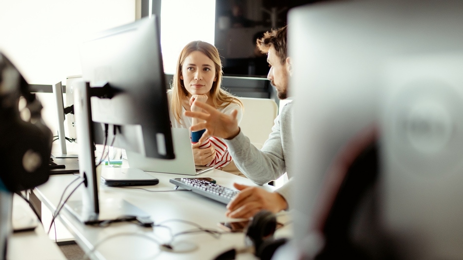 Hombre y mujer cotejando datos en un ordenador