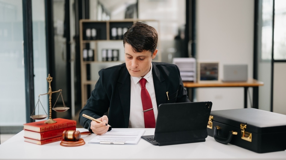 Abogado trabajando en una mesa con un portátil y documentos