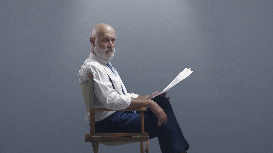 Hombre adulto sentado en una silla leyendo