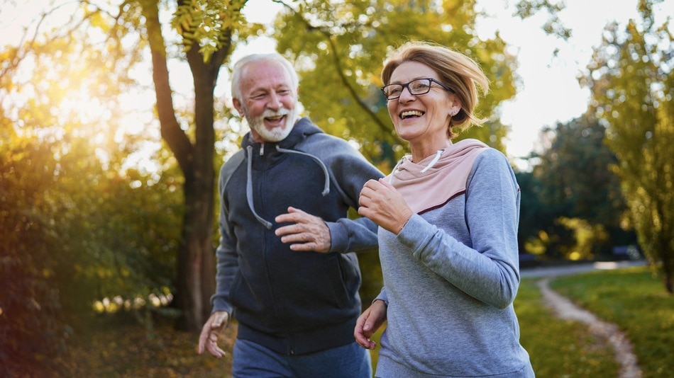 Alegre pareja de ancianos corriendo en el parque