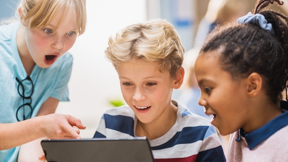 Niños en clase, jugando, aprendiendo con una tablet