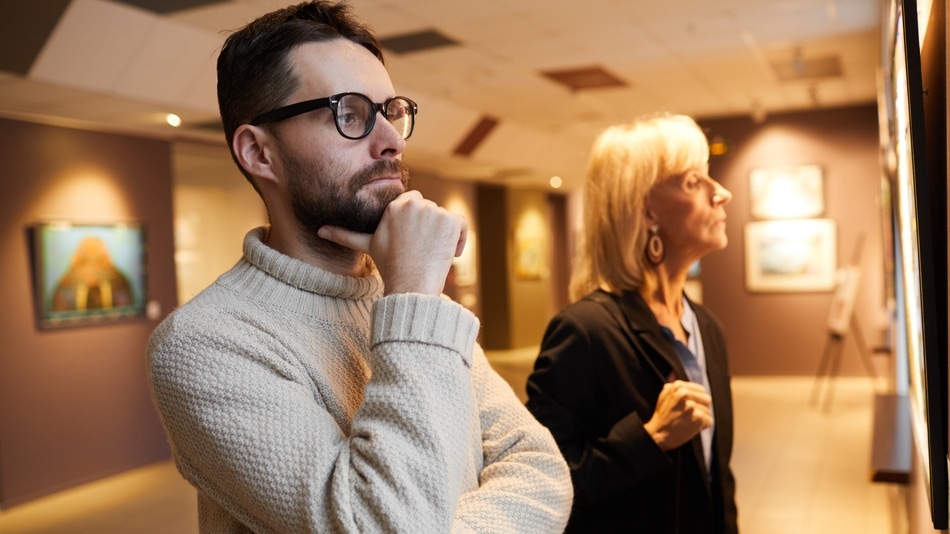 Dos personas mirando pinturas en un museo