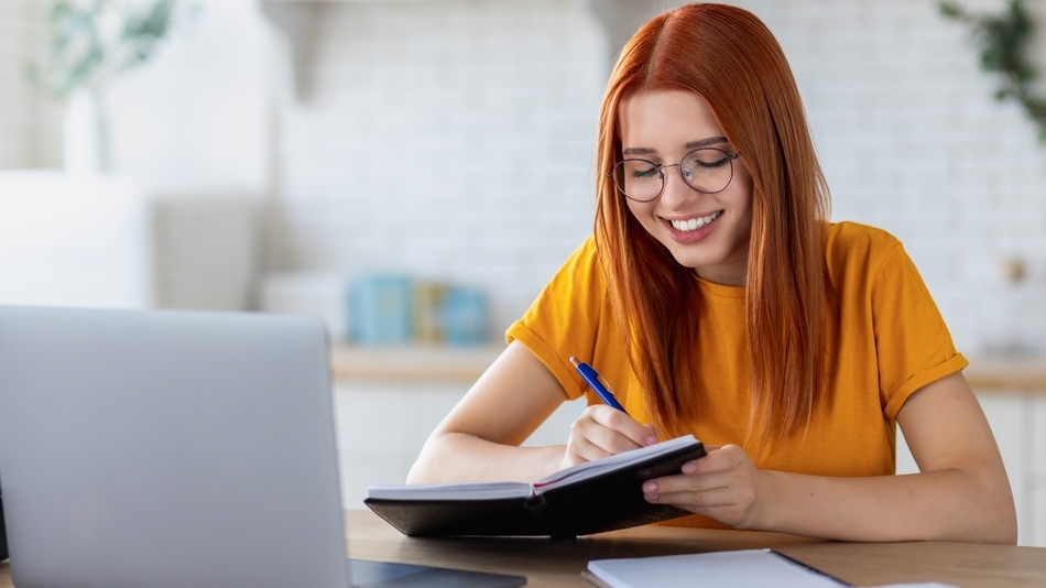 Joven estudiante caucásica usando computadora portátil