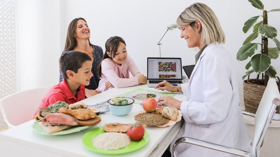 Nutricionista y pequeños pacientes con su madre durante una consulta