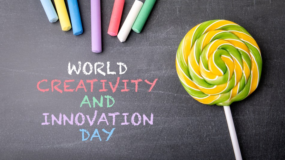 Día Mundial de la Creatividad y la Innovación. Trozos de tiza de colores en una pizarra oscura