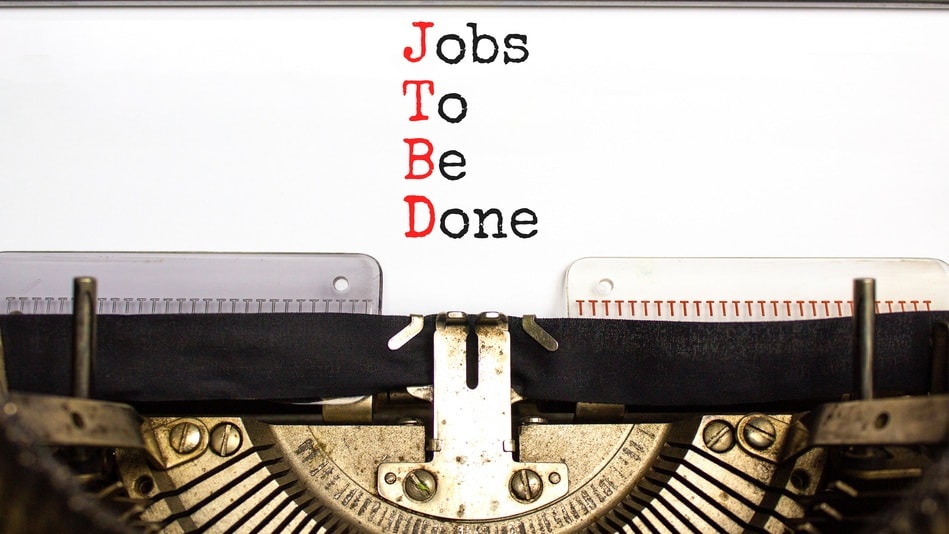 Símbolo de trabajos a realizar JTBD, sobre una hoja en blanco en una maquina de escribir