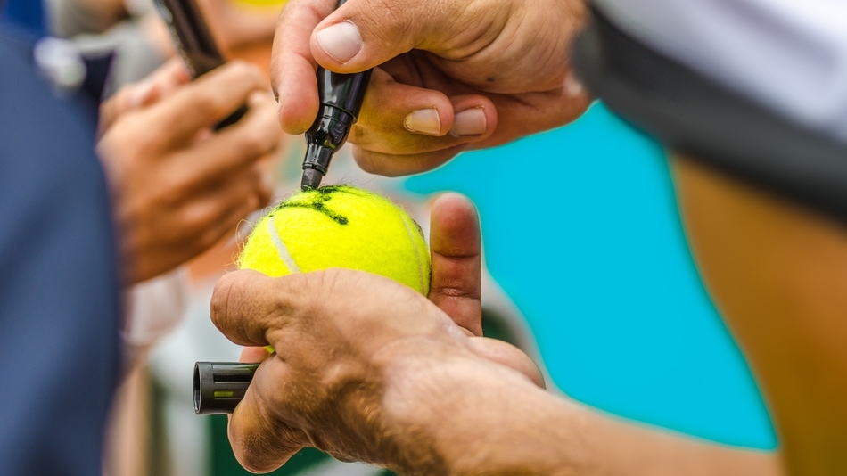 Jugador de tenis firmando autógrafo en un evento deportivo