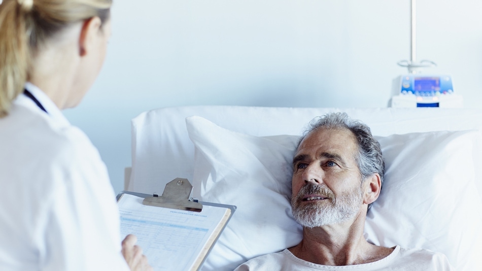 Hombre en cuidados paliativos escuchando atentamente a la doctora