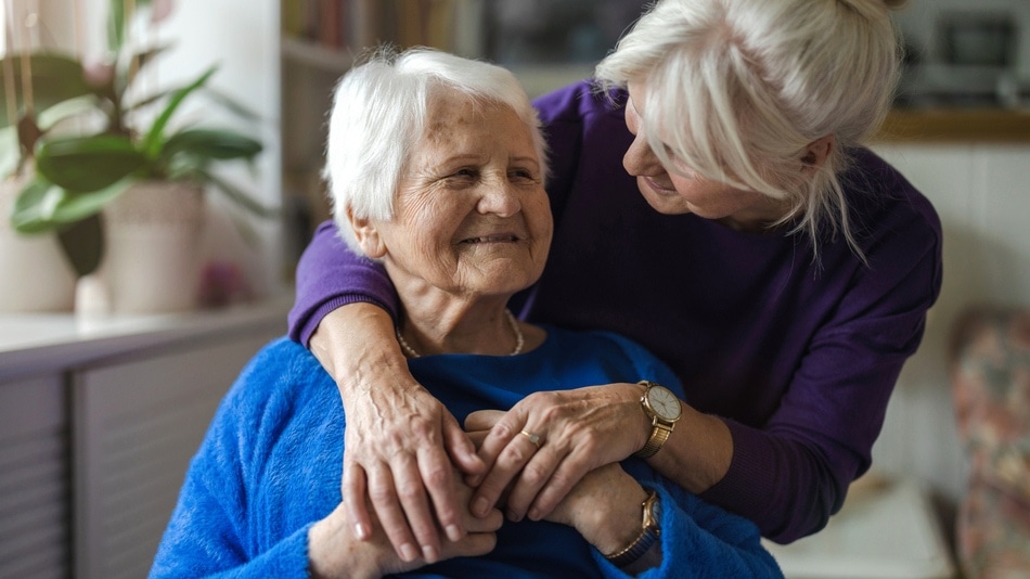 Abrazando a su anciana madre