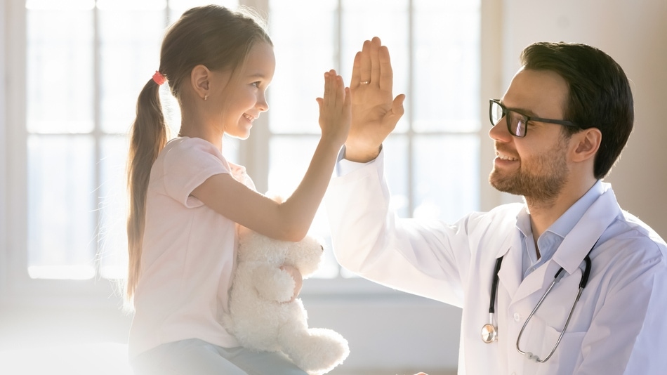 Niña choca la mano con el doctor por su satisfacción del paciente