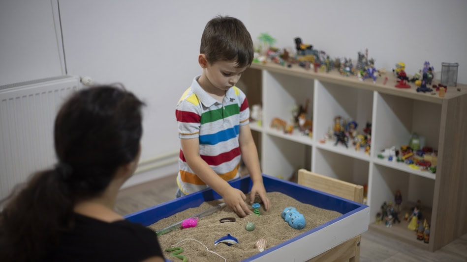 Niño utilizando la técnica de la caja de arena