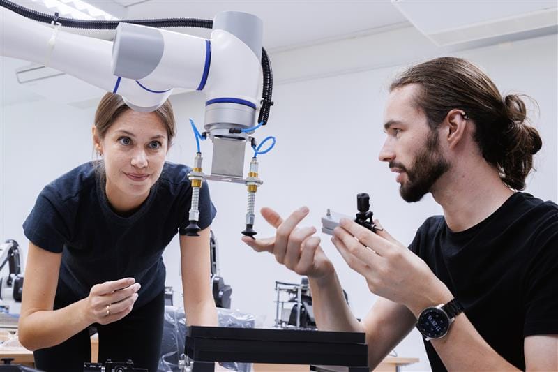 Graduados trabajando con tecnología robótica en un entorno técnico tras cursar el Grado en Ingeniería Electrónica Industrial y Automática en UNIR.