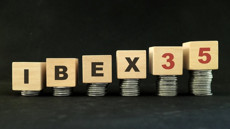 Cubos de madera apoyados sobre pila de monedas con la palabra Ibex 35