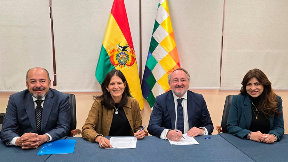 En el centro de la imagen, Beatriz Elena García de Acha y Manuel Herrera firman el acuerdo.