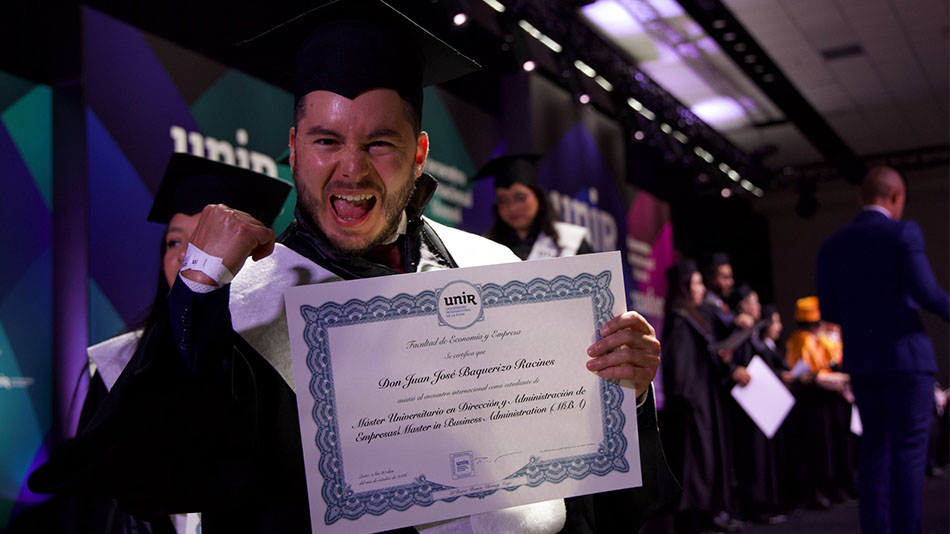 Estudiante exultante muestra su diploma.