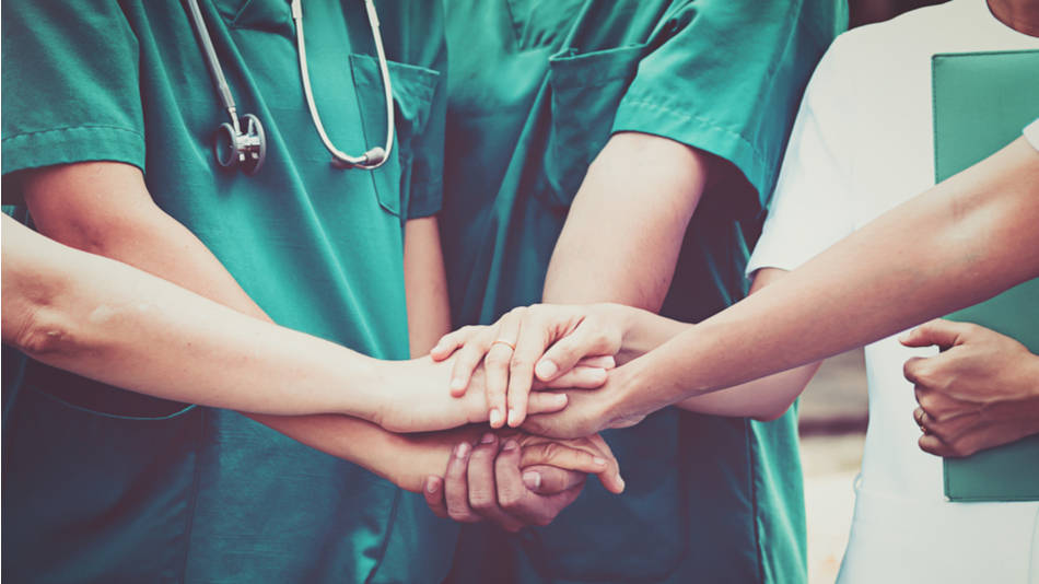 enfermeros con las manos juntos en apoyo