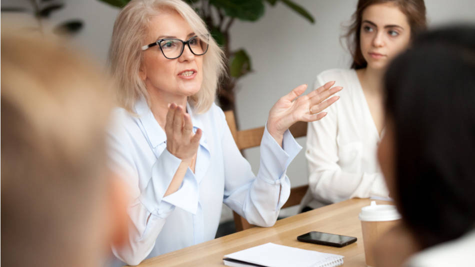 Una mujer mayor liderando un equipo interesado