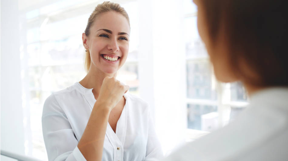 Inteligencia emocional; dos compañeras de trabajo hablan felizmente