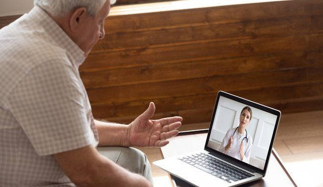 Hombre mayor con cita online con doctora