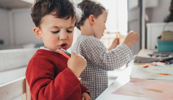 Niño con rotuladores en la mano. 