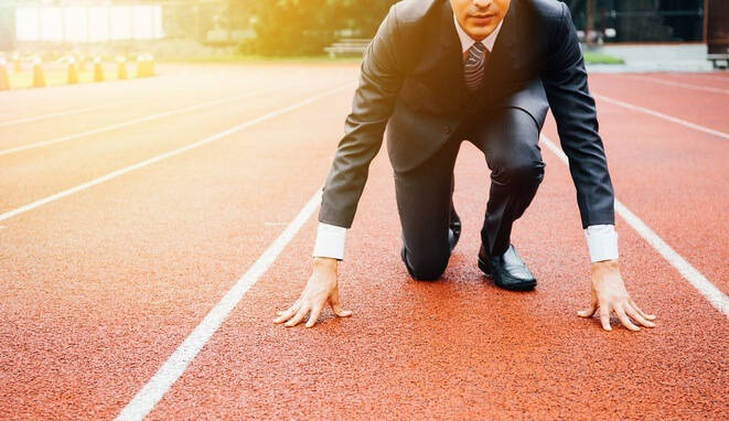 Ejecutivo en la línea de salida de una pista de atletismo. 