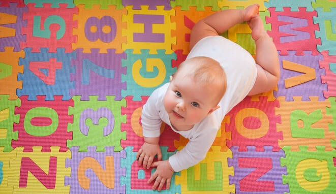 Psicomotricidad fina y gruesa. Bebé sobre alfombra de juegos. 