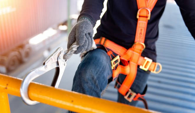 Trabajador de la construcción con seguridad y arnés. 