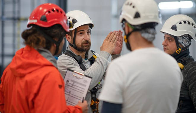 Trabajadores valorando los riesgos de una empresa. Van todos con casco. 