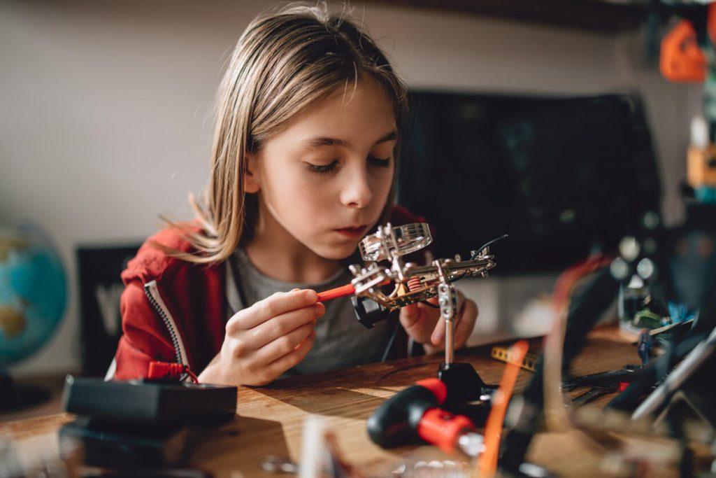 Niña trabajando en un robot. 