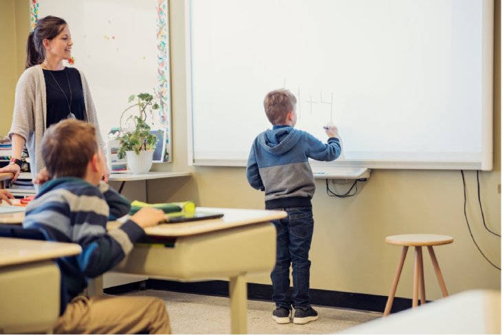 Niño escribiendo en pizarra