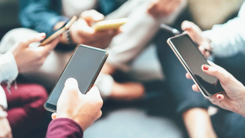 Adicción a la tecnología. Un grupo de amigos y cada uno tiene el móvil en la mano.