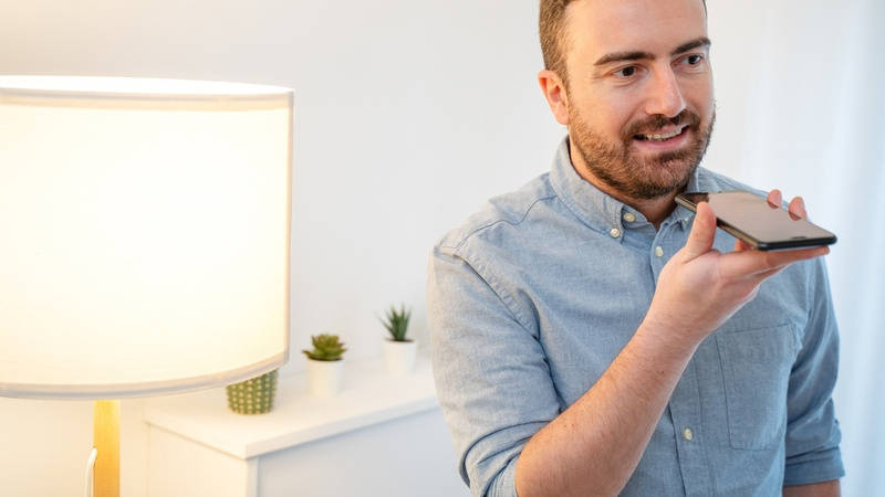 Hombre utiliza un asistente de voz de su teléfono móvil.