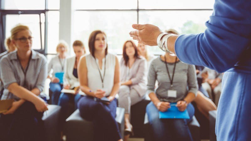 Educación, Plan General Anual; la directora de un centro educativo habla a los profesores en una reunión para programar el Plan General Anual