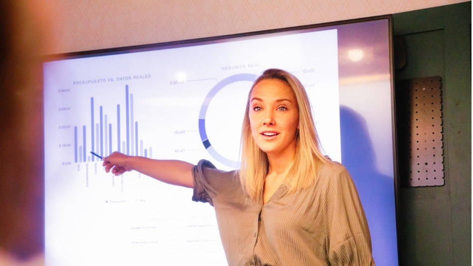 Marketing, machine learning; una mujer rubia señala a datos durante una presentación