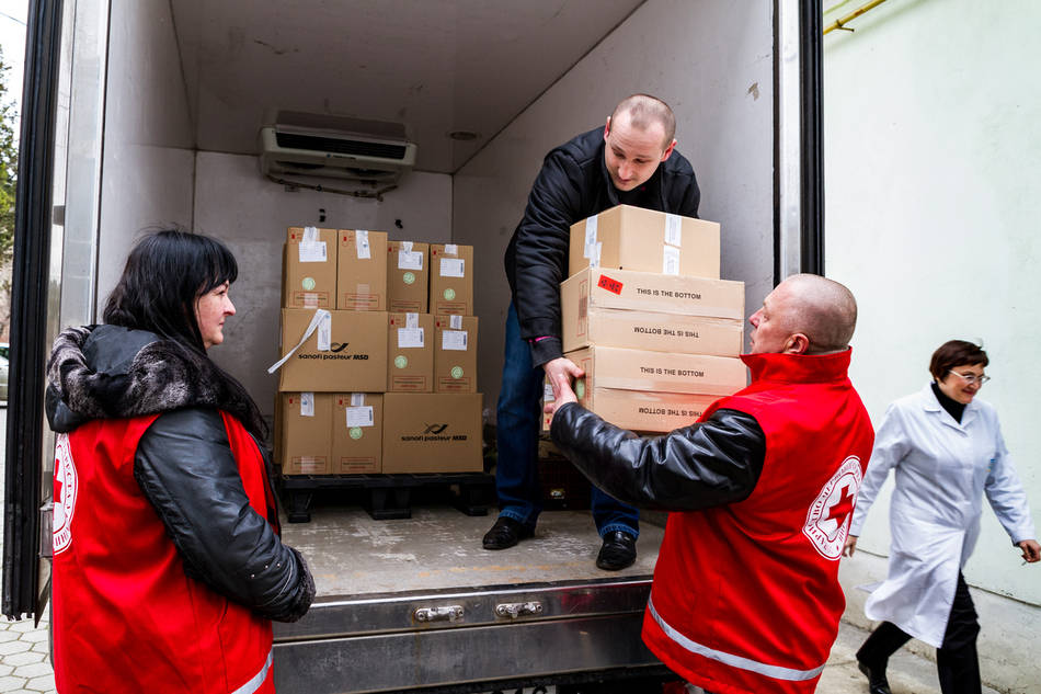 acción humanitaria, voluntariados descargando cajas de un camión