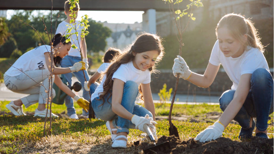 Intervención sociocomunitaria, niñas plantando árboles 