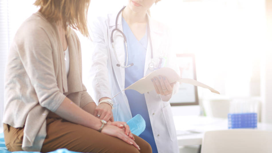 Una mujer recibe un diagnóstico médico y consolación de su doctora